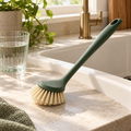 Dish brush beside a clean kitchen sink