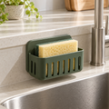 Ventilated sponge holder beside a kitchen sink